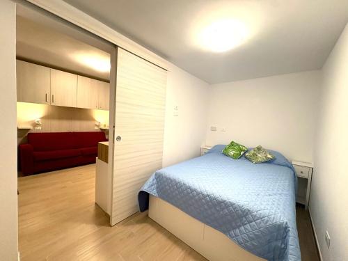 a small bedroom with a bed and a red couch at Hostdomus - Lizzie's House in Alassio