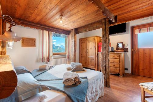 a bedroom with a large bed and a wooden ceiling at Affittacamere Jour Et Nuit in Torgnon
