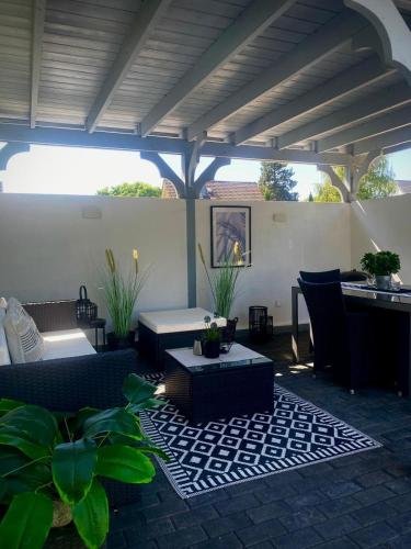 an outdoor patio with couches and a table and chairs at Ferienwohnung Paradies Hella in Kippenheim