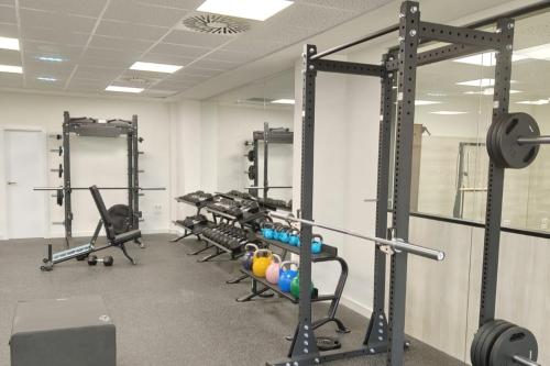 a gym with a row of tread machines and weights at PONTIANA Thalasso Hotel in Oropesa del Mar