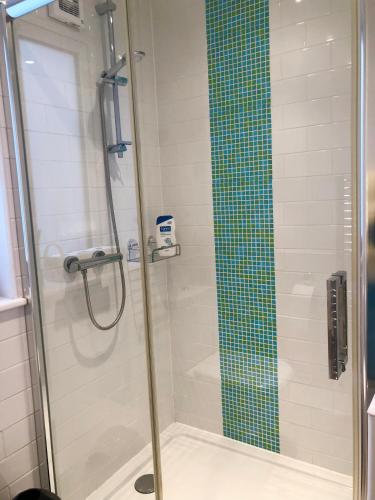 une douche avec une porte vitrée dans une salle de bain dans l'établissement Sunsets, Sandylands Prom Morecambe, à Morecambe