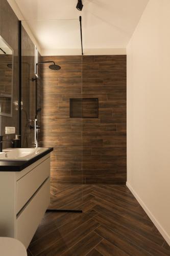 a bathroom with a glass shower with a sink at Nest Inn Charm Apartment in Baia Mare