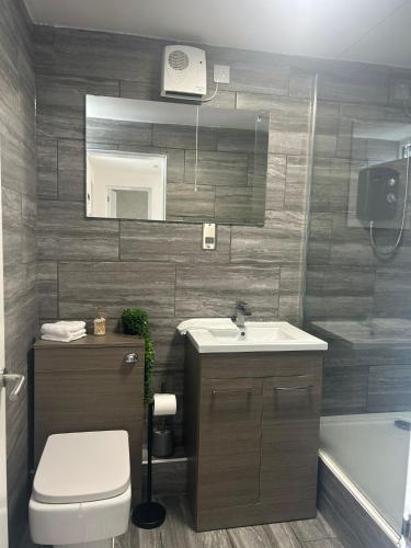a bathroom with a sink and a toilet and a tub at Muirside Cottage in Stirling