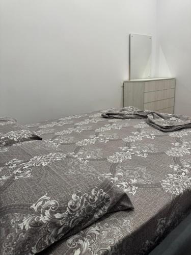 a bed with a black and white blanket on it at Halim zeneli in Tirana