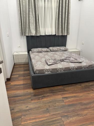 a bed in a room with a wooden floor at Halim zeneli in Tirana