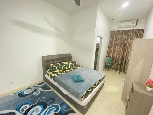 a bedroom with a bed with blue slippers on it at Homestay Teratak Tamu Tawau in Tawau