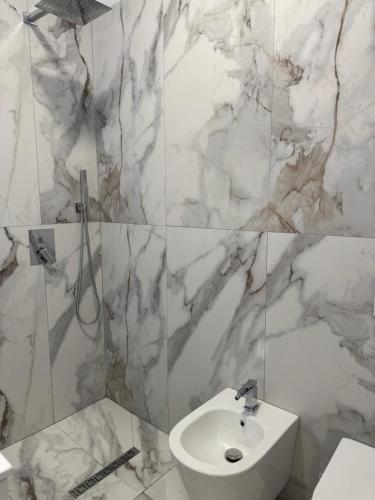 a white bathroom with a sink and a toilet at Halim zeneli in Tirana
