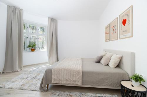 Un dormitorio blanco con una cama y una ventana. en Beautiful Apartment in Erdody Palace, en Otilia