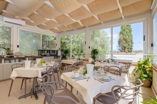 a restaurant with tables and chairs and large windows at Residence Poggio Golf Chianti Firenze in Impruneta