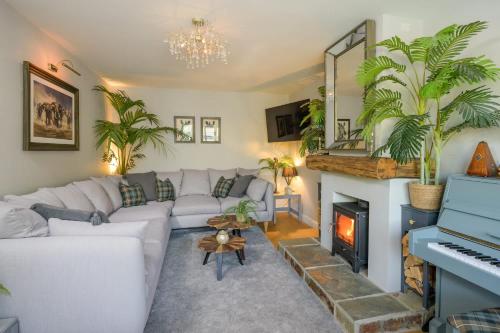a living room with a white couch and a fireplace at Beautiful Home & Garden in Somerset Countryside in East Lydford