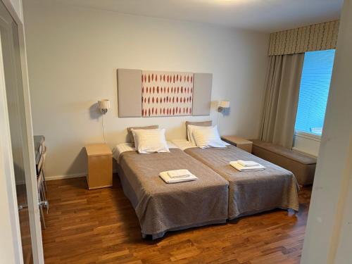 a bedroom with a bed with two towels on it at Tallukantie Sauna-apartamentti in Asikkala