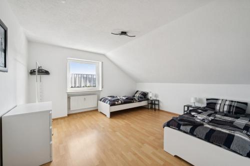 a white room with two beds and a window at Cosy Worker Apartment Olpe in Olpe