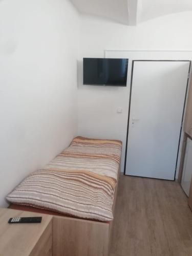 a small bedroom with a bed and a door at Ubytování Louny in Louny