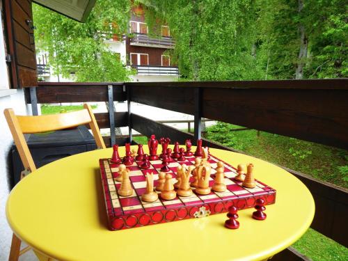 a chess set on a yellow table on a balcony at Chalet Giove in Belluno