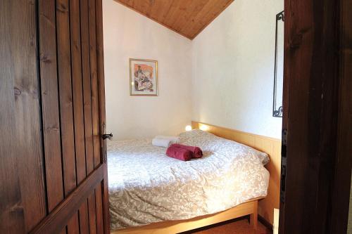 a small bedroom with a bed with a red bag on it at Chalet Giove in Belluno