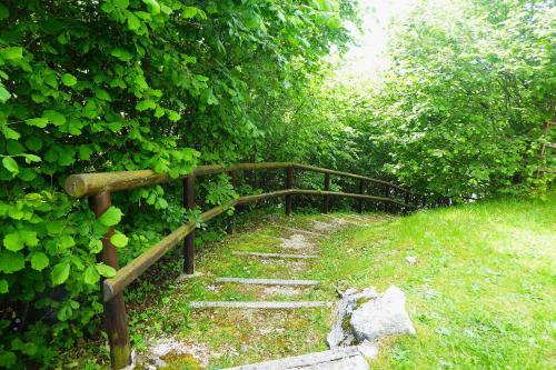 a stone path with a wooden bridge in a park at Chalet Giove in Belluno