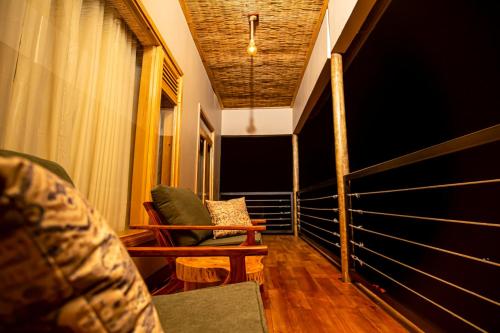 a room with a balcony with a couch and chairs at Burunga Gorilla Lodge in Kisoro