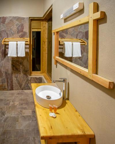 a bathroom with a sink on a wooden counter at Burunga Gorilla Lodge in Kisoro