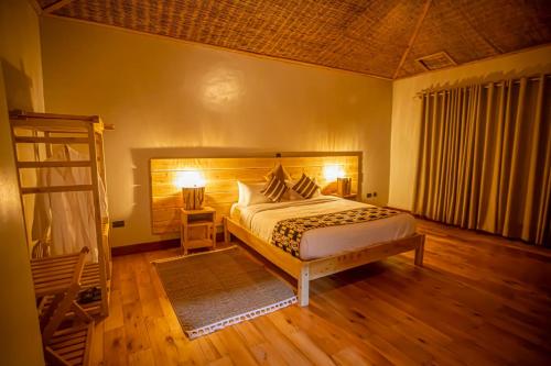 a bedroom with a bed and a wooden floor at Burunga Gorilla Lodge in Kisoro