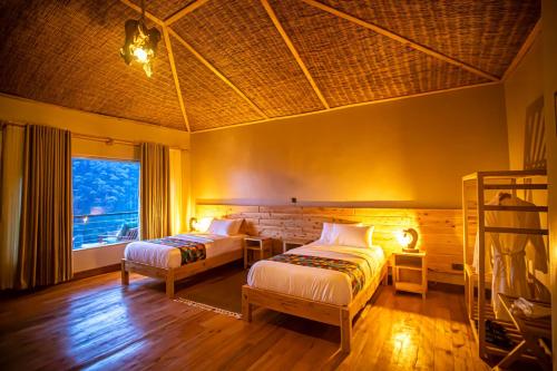 a bedroom with two beds and a window at Burunga Gorilla Lodge in Kisoro