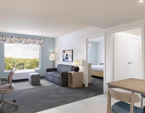 a living room with a couch and a bedroom at Home2 Suites By Hilton Calera in Calera