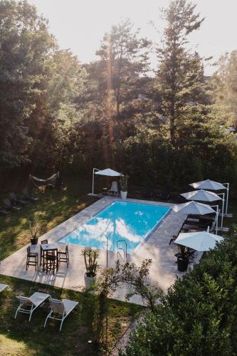 a swimming pool with tables and chairs and umbrellas at Ewitsch 13 - Hotel Garni in Berghausen