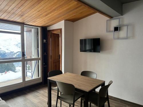 a dining room with a table and chairs and a window at Casa Vacanza in Prato Nevoso