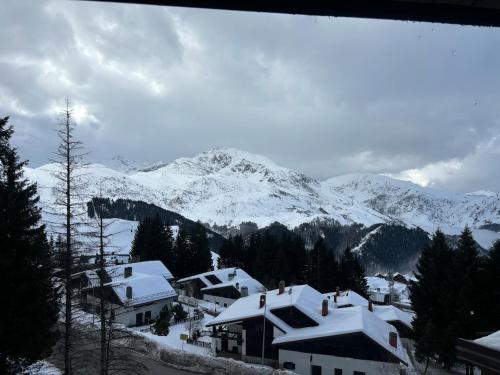 a snow covered mountain with houses and snow covered roofs at Casa Vacanza in Prato Nevoso