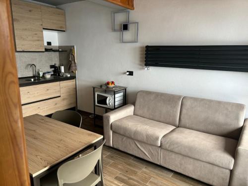a living room with a couch and a kitchen at Casa Vacanza in Prato Nevoso