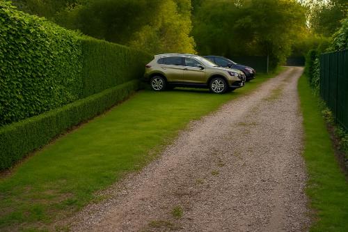 two cars parked on a dirt road next to a hedge at Baita Cao Como Lake in Brunate