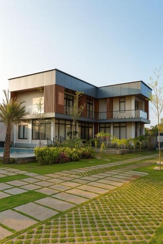 a building with a lawn in front of it at Swagatha The Beach House 3Bhk Villa in Tirupporūr