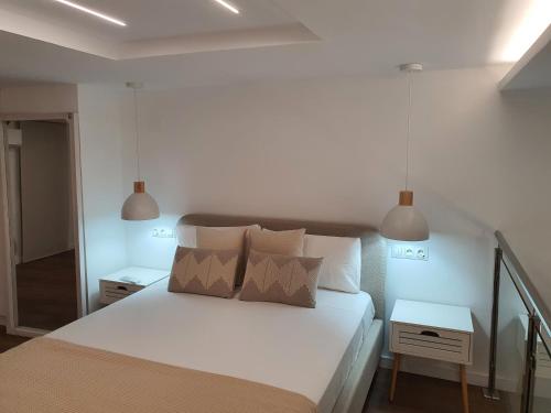 a bedroom with a white bed with two lamps at Espacio 21 in Córdoba