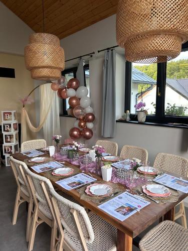 a long wooden table with chairs and balloons at Casa Guzinni in Písečná