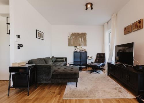 a living room with a couch and a television at Ewitsch 13 - Hotel Garni in Berghausen