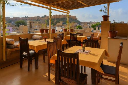 een restaurant met tafels en stoelen en uitzicht op de stad bij Jaisalmer Grand Palace in Jaisalmer