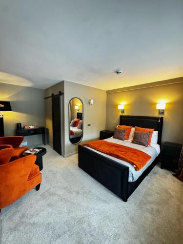 a bedroom with a large bed and a mirror at Chequers Inn in Harrogate