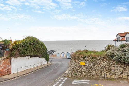 a road with houses and the ocean in the background at Meri Rauha in Felixstowe