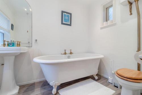 a white bathroom with a tub and a toilet at Meri Rauha in Felixstowe