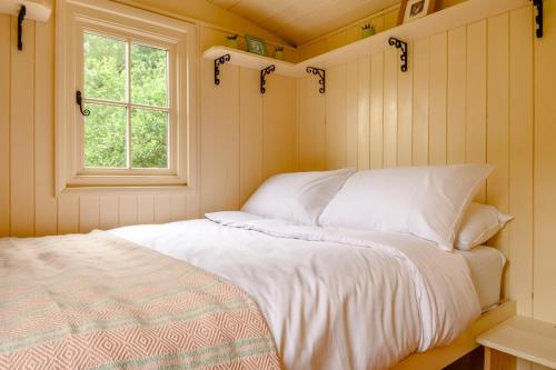 a bedroom with a white bed and a window at The Orchard Hut in Burnham Market