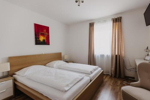 a bedroom with a bed and a desk and a chair at Ewitsch 13 - Hotel Garni in Berghausen