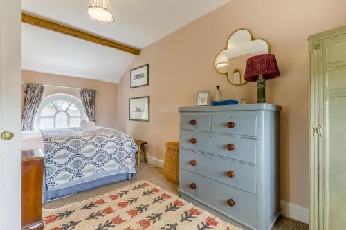 a bedroom with a blue dresser and a bed at The Ostlery in Tunstead