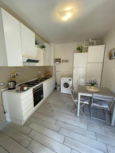 a kitchen with white cabinets and a table and a stove at Guest-House Del Corso in Montepulciano