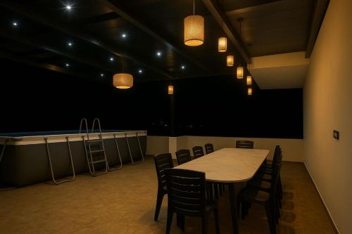 a dining room with a table and chairs and lights at Swagatha The Beach House 3Bhk Villa in Tirupporūr