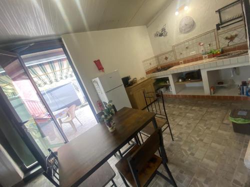 a kitchen with a table and a refrigerator at Le Decime in Mascali