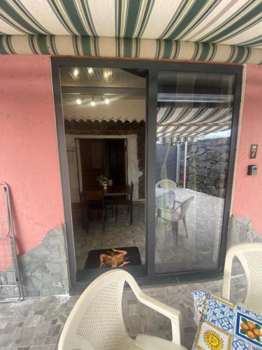 a screened in patio with a table and chairs at Le Decime in Mascali