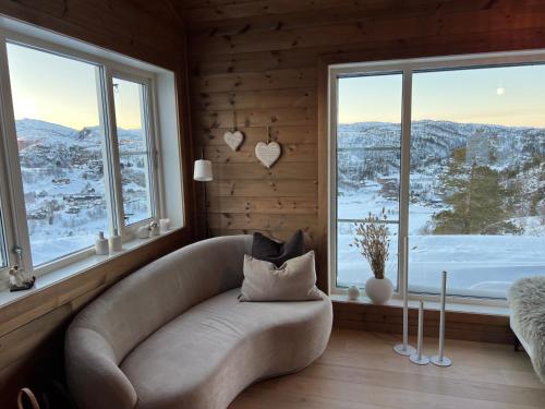 a living room with a couch and a large window at Fantastic view, great holiday in Tjørhom Sirdal in Haugen