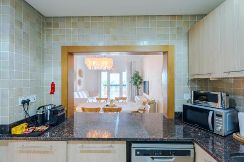 a kitchen with a counter top and a living room at Glamorous Modern 2BHK in Yas Island 324 in Abu Dhabi