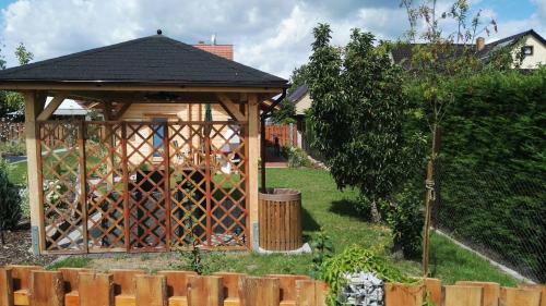 a wooden gazebo with a fence in a yard at Spreewaldhäuser Wiesner in Lübbenau