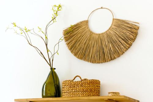 a mirror and a vase on a shelf with a basket at Glamorous Modern 2BHK in Yas Island 324 in Abu Dhabi