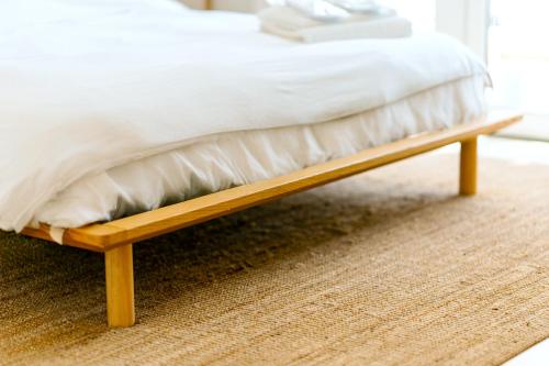 a wooden bed frame with a white mattress at Glamorous Modern 2BHK in Yas Island 324 in Abu Dhabi